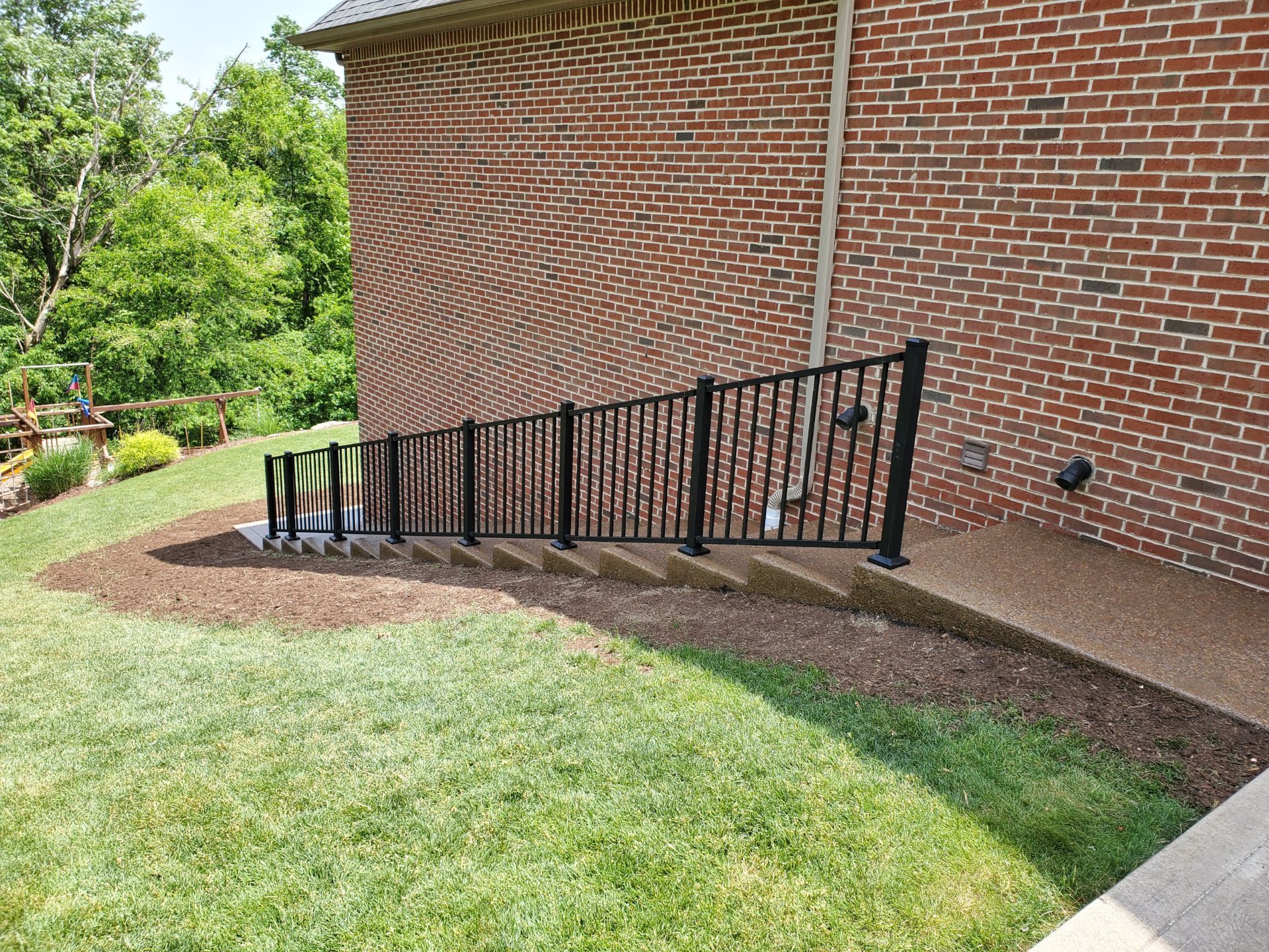 A brick building with stairs and a fence in front of it.
