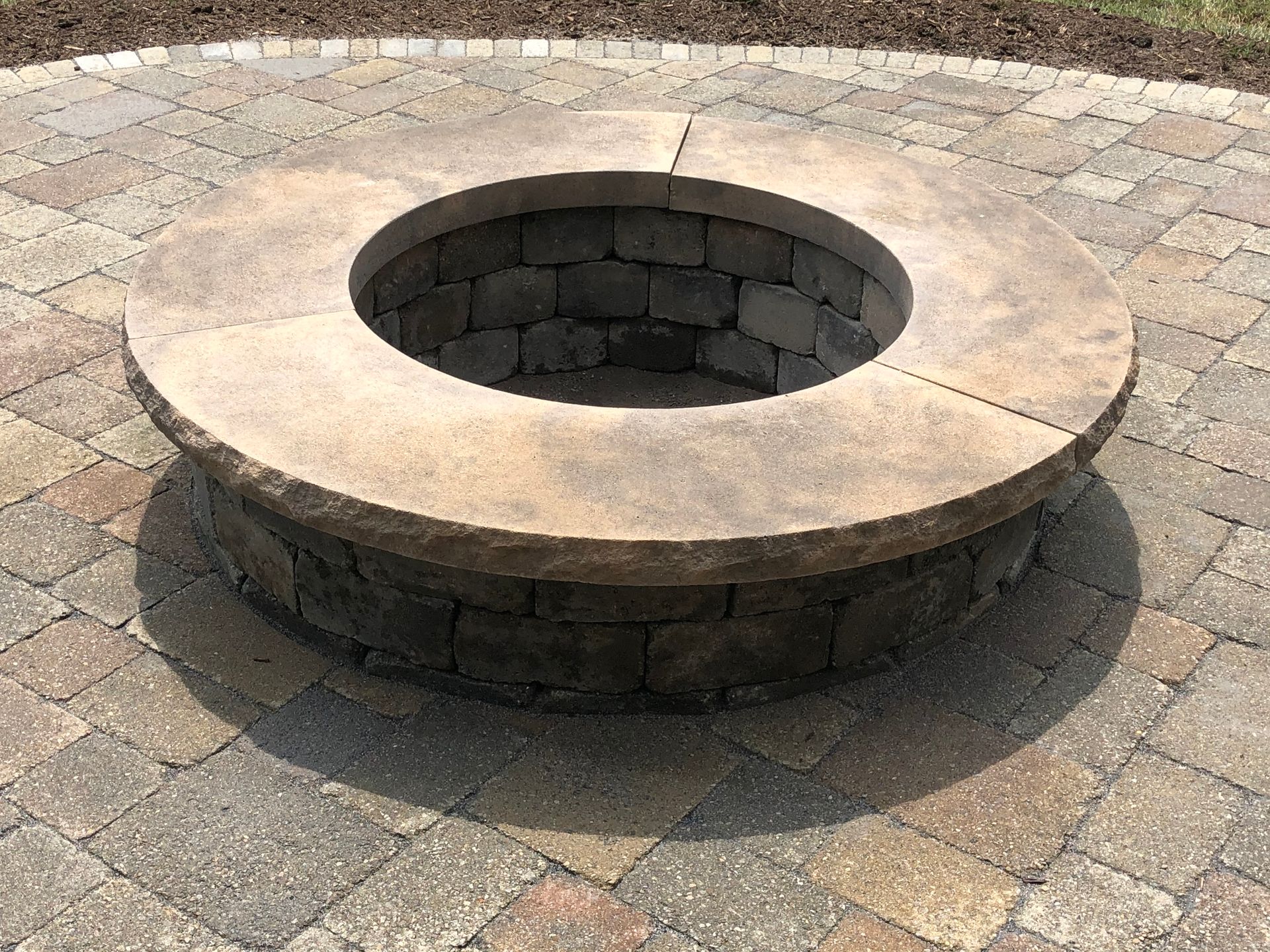 A fire pit is sitting on top of a brick patio.