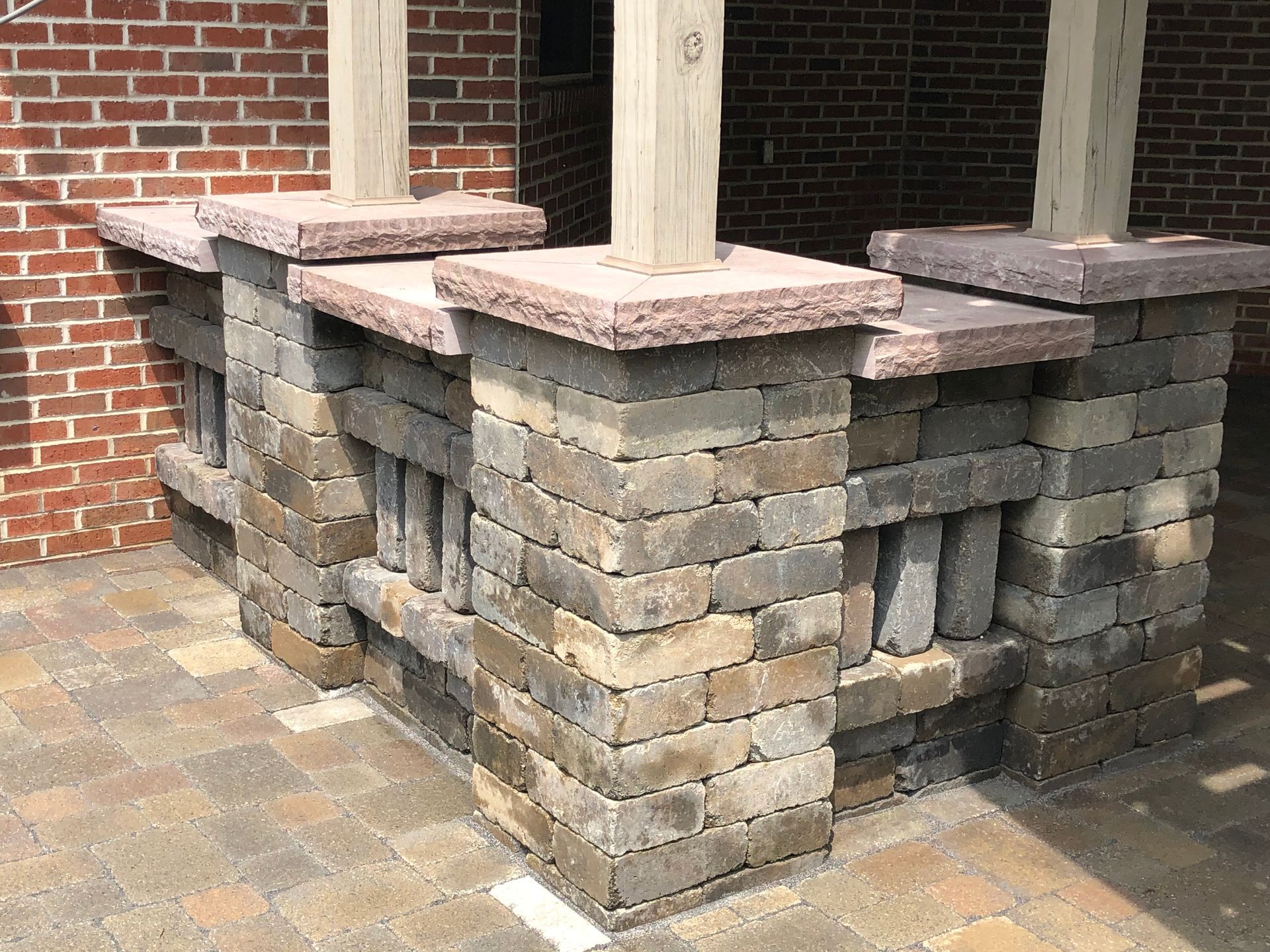 A brick wall with a wooden post in front of a brick building.