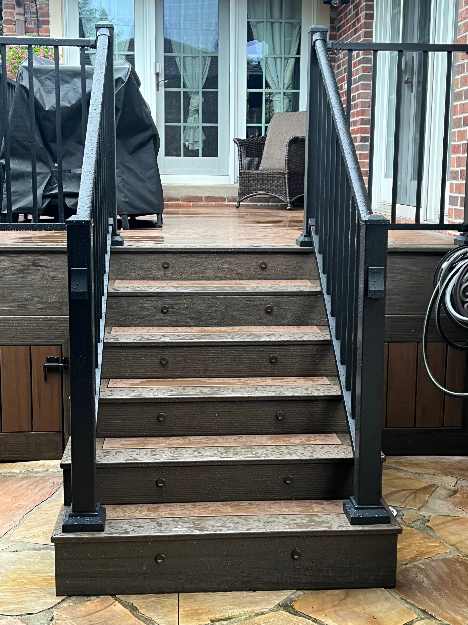 A set of stairs leading up to a deck with a black railing