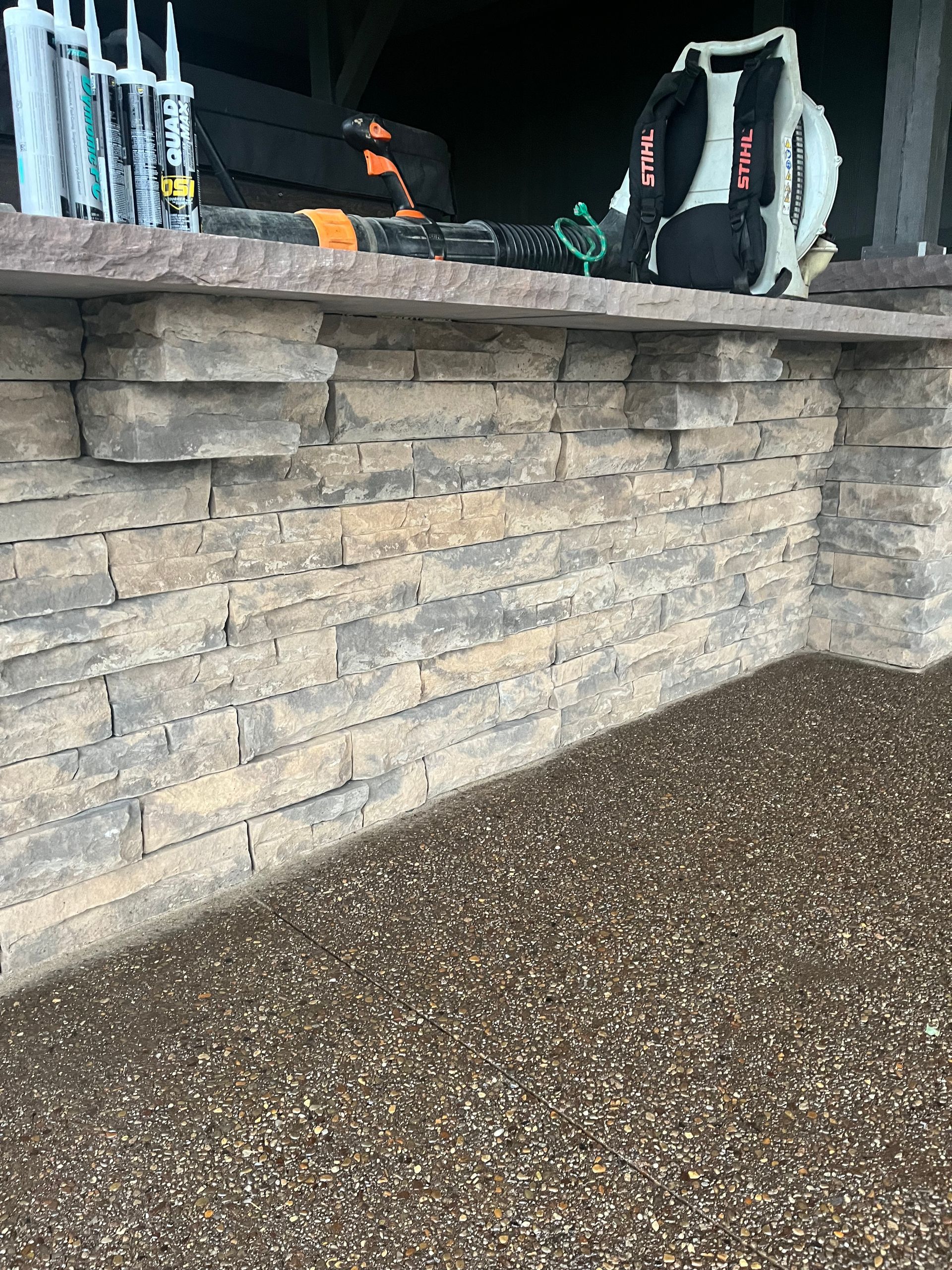 A brick wall with a blower on top of it.