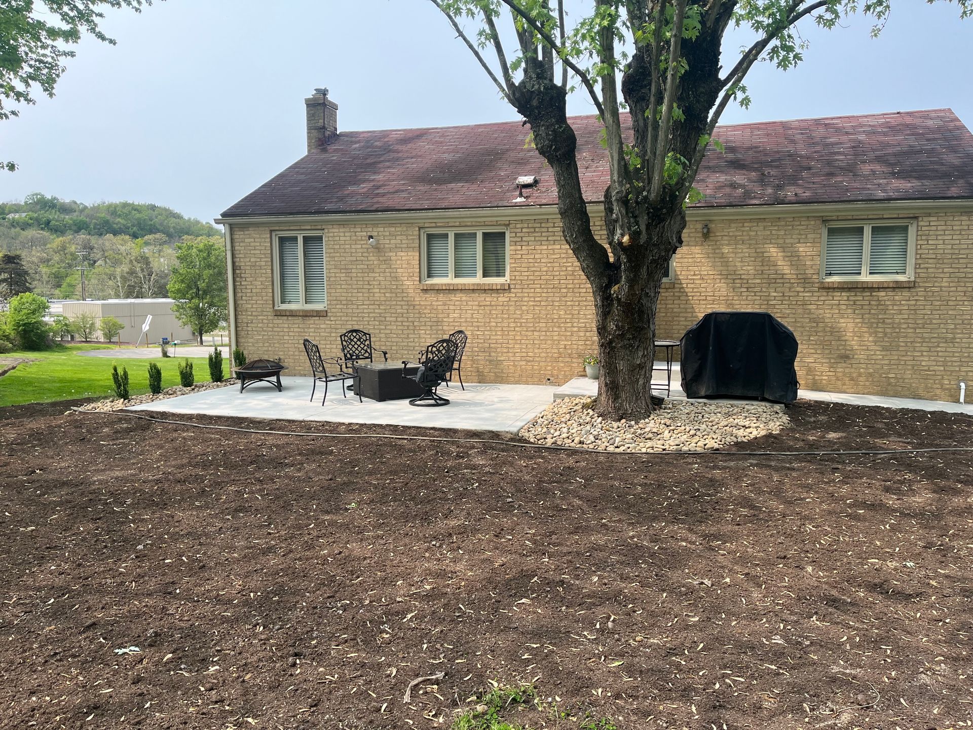 A house with a patio and a tree in front of it.