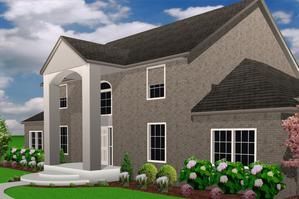 A two-story grey brick house with a white pillared entrance and dark roof, surrounded by green landscaping under a blue sky.
