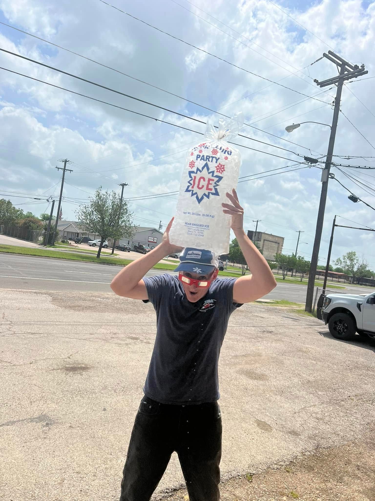 A man is holding a bag over his head in a parking lot.