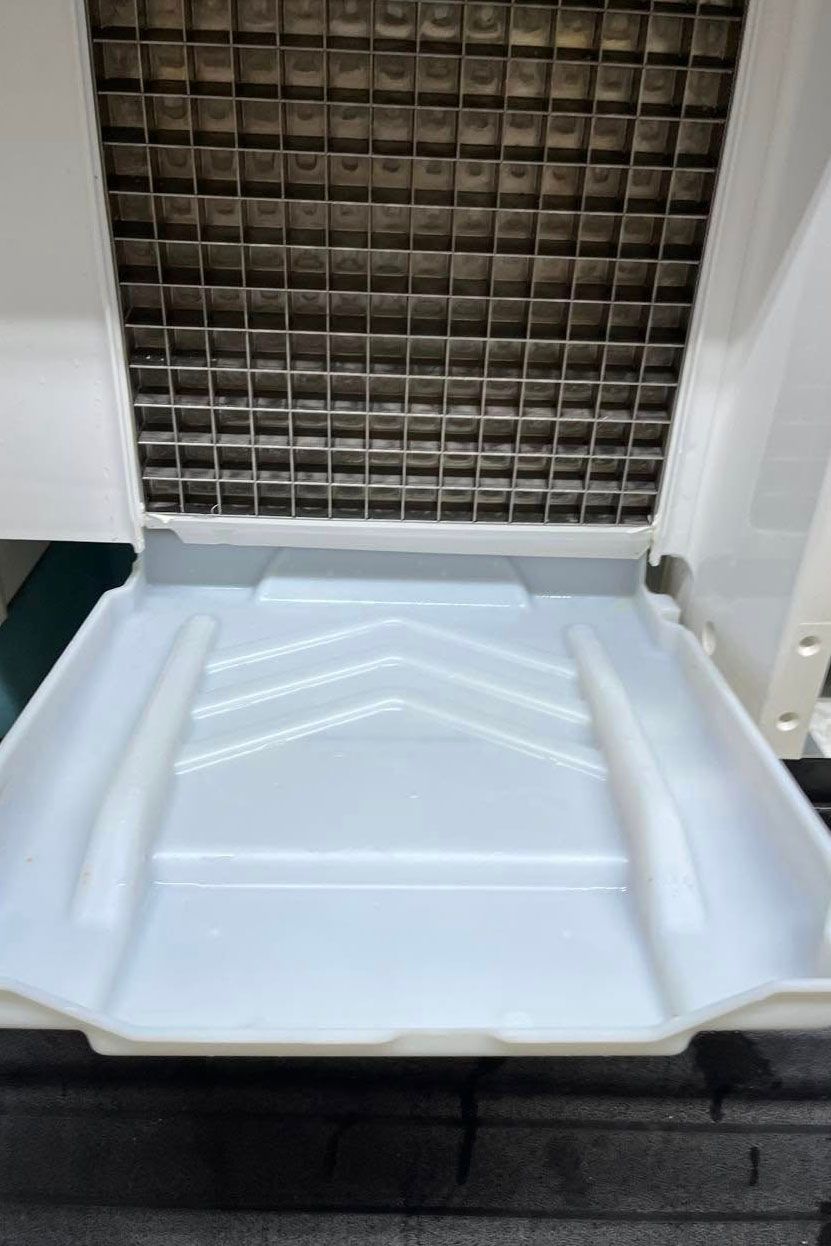 A cleaned ice cube maker is sitting on top of a counter.