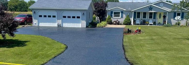 A driveway leading to a house with a car parked in front of it.