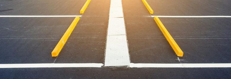 A close up of a road with yellow lines and a white line.