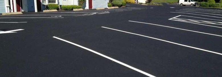 A parking lot with white lines on it in front of a building.