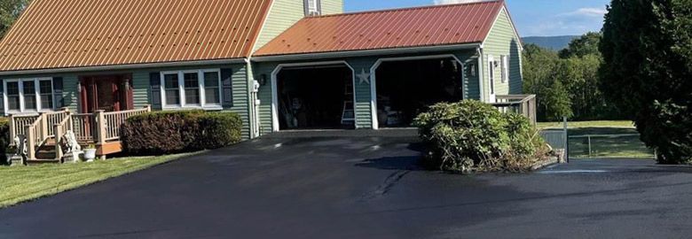 A house with a garage and a driveway in front of it.
