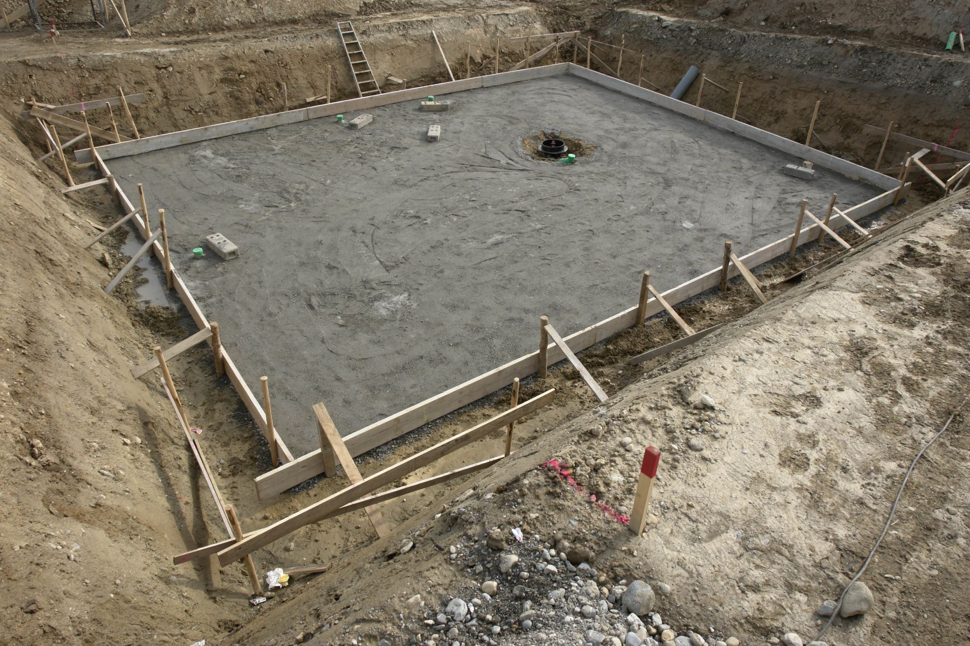 Concrete foundation poured in wooden forms on a construction site.