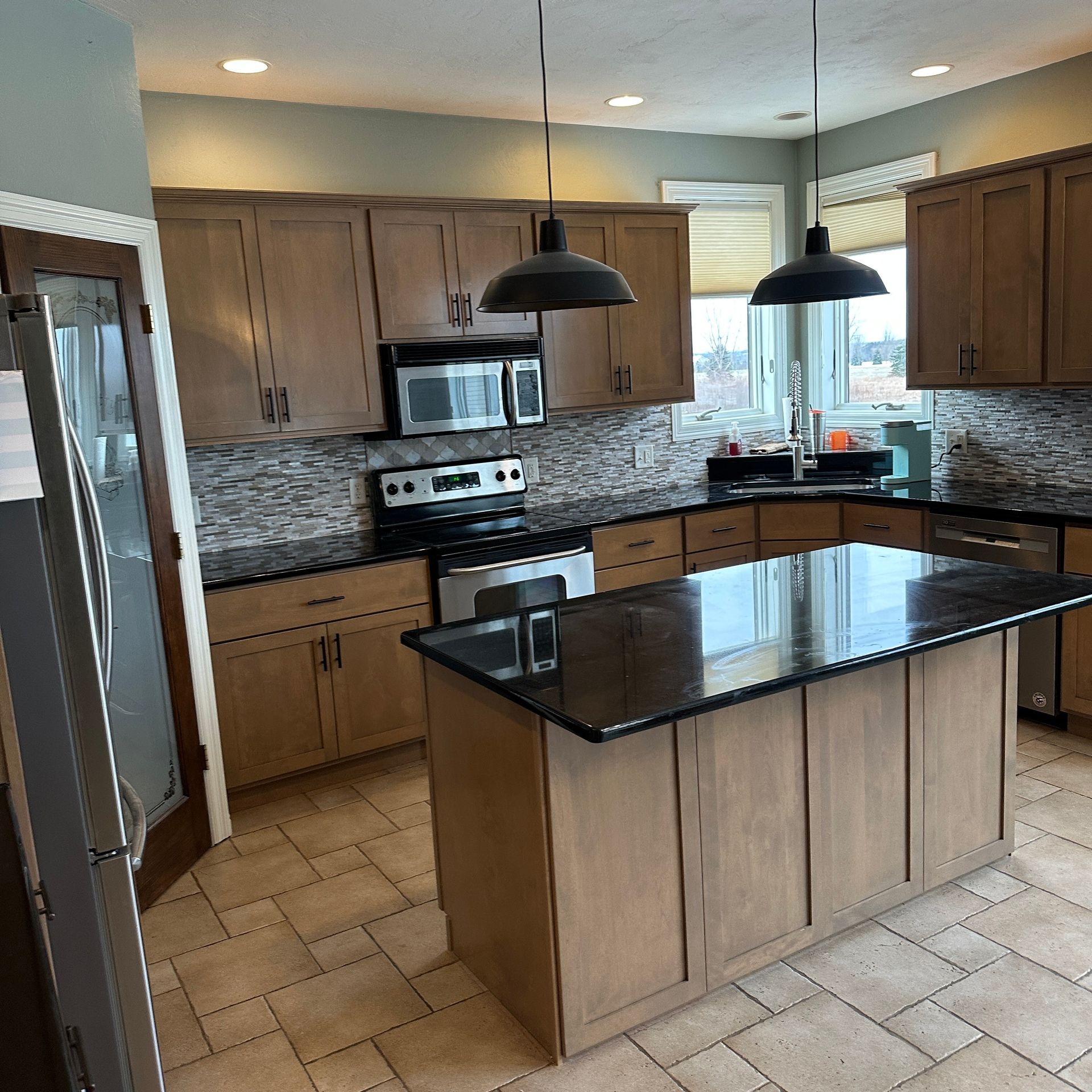 A kitchen with wooden cabinets and black counter tops