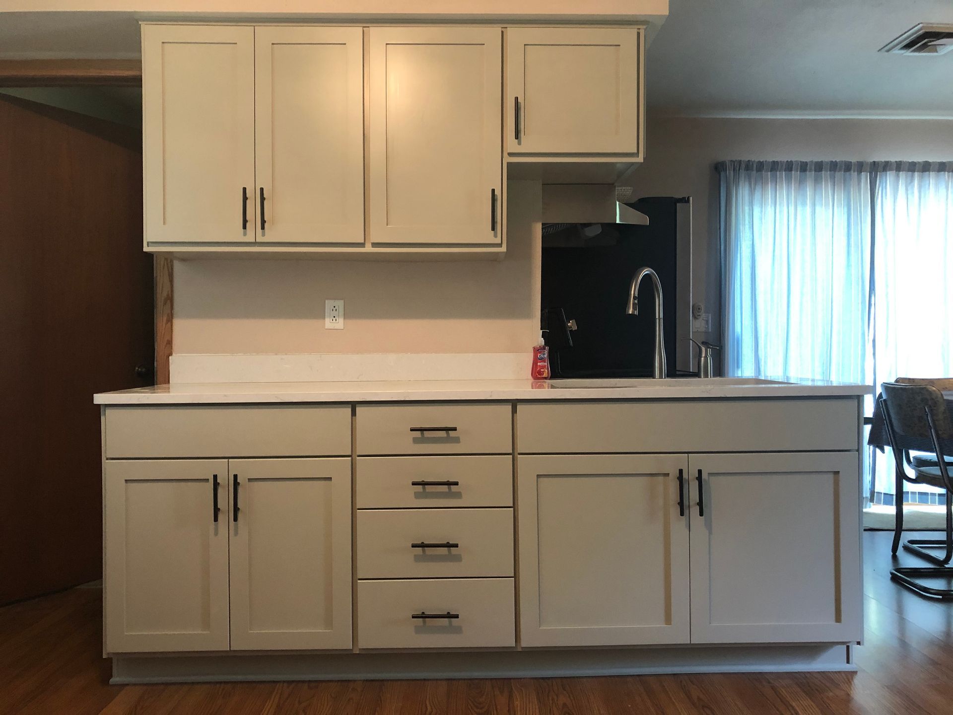 A kitchen with white cabinets and drawers and a sink