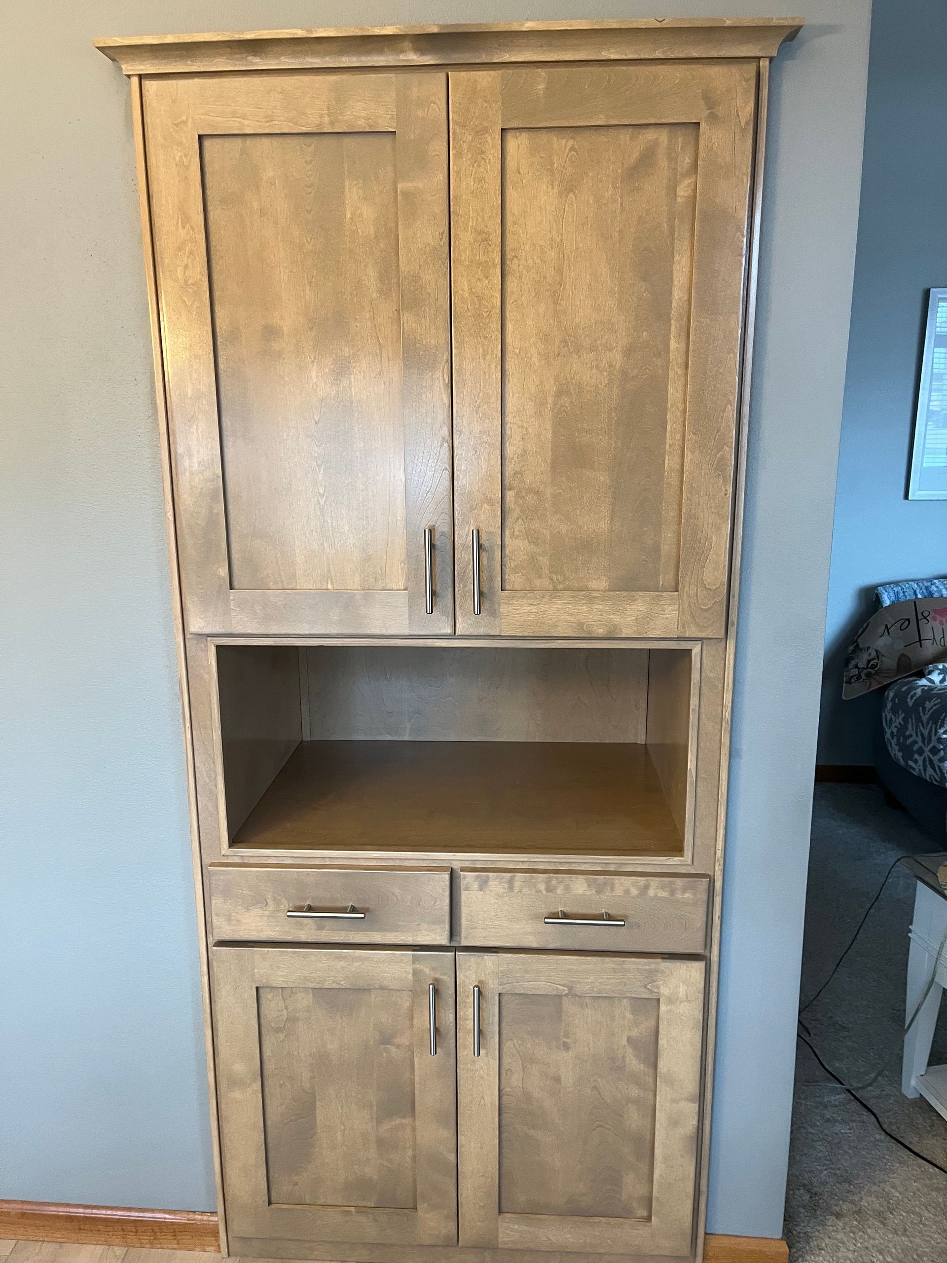 A wooden cabinet with two doors and two drawers in a room.