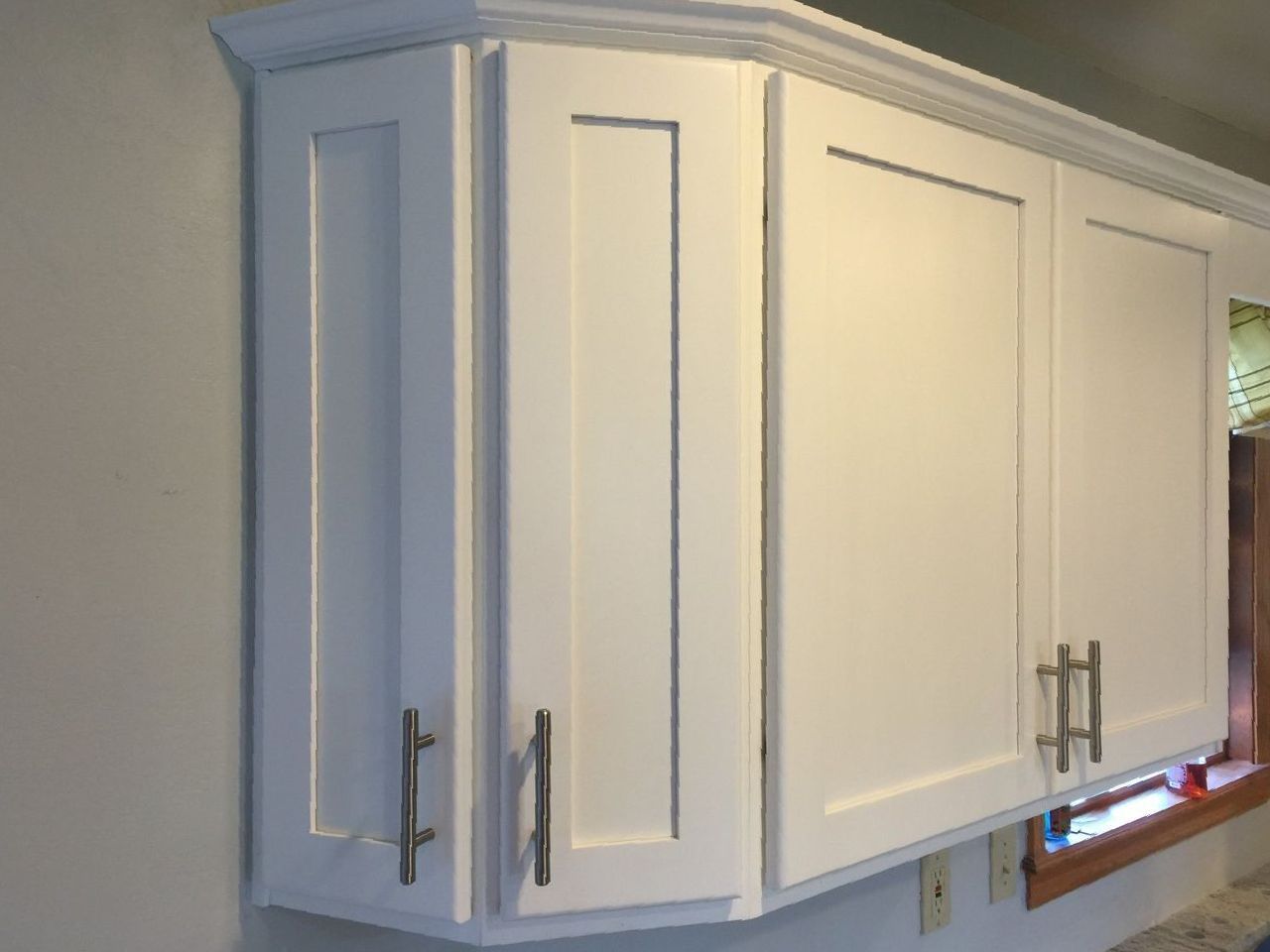 A kitchen with white cabinets and a window