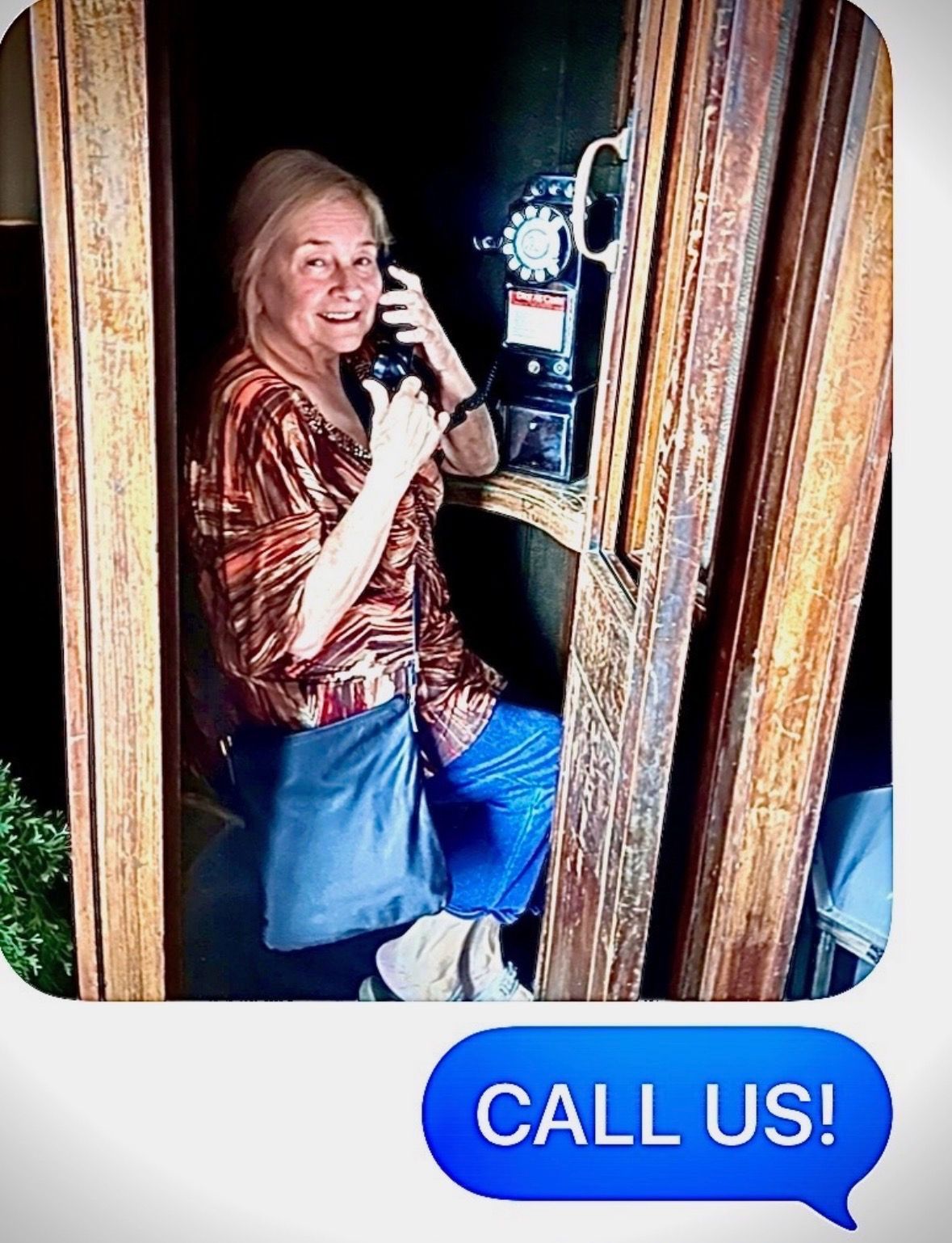 Smiling woman using a phone in a wooden booth, with a blue “CALL US!” button below.