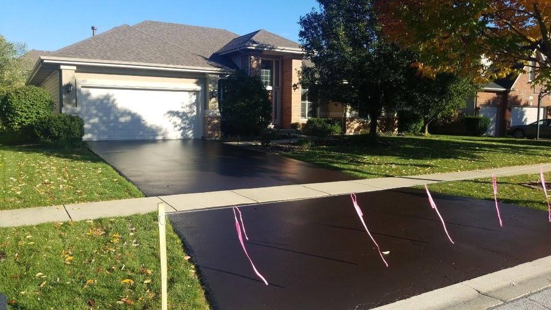 A seal coated driveway in front of a house