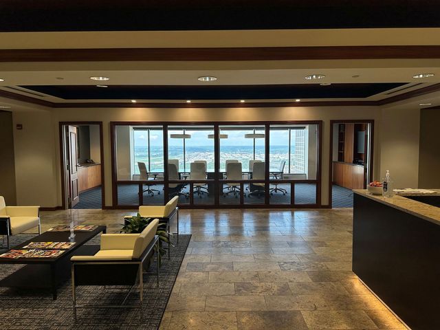 Modern hotel buffet area with seating, serving stations, and large windows overlooking the ocean.