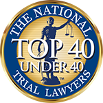 Round gold and blue National Trial Lawyers “Top 40 Under 40” emblem with female figure silhouette