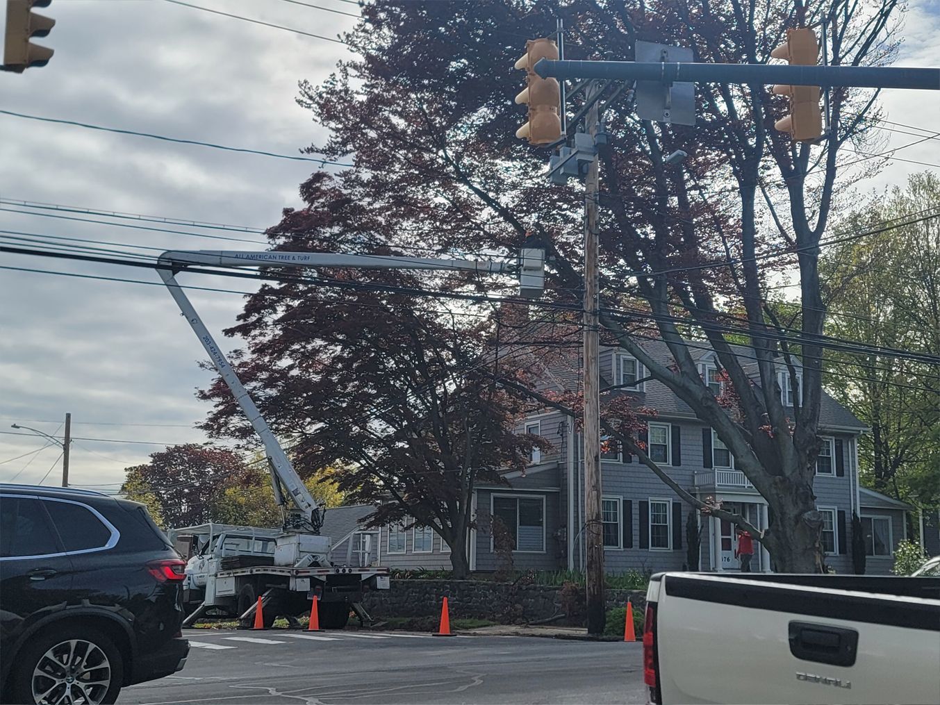 A truck is parked on the side of the road in front of a traffic light.