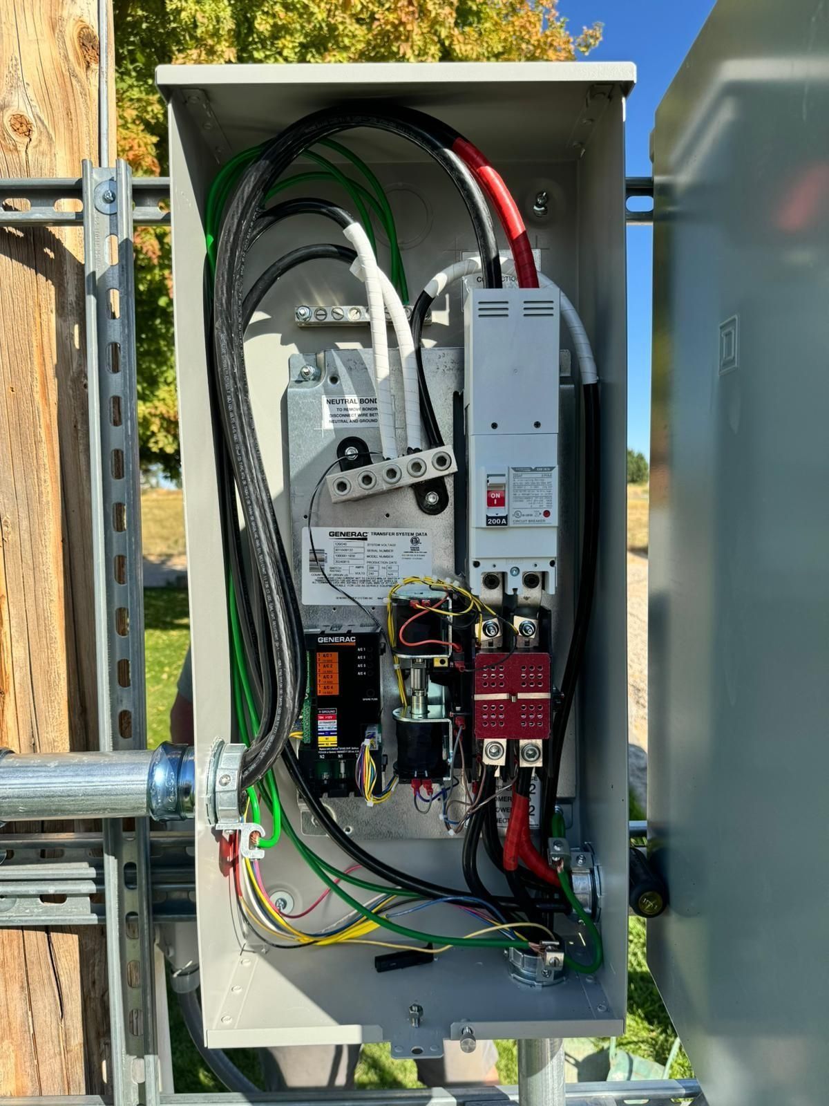 Open electrical panel with wiring and components mounted on a utility pole.