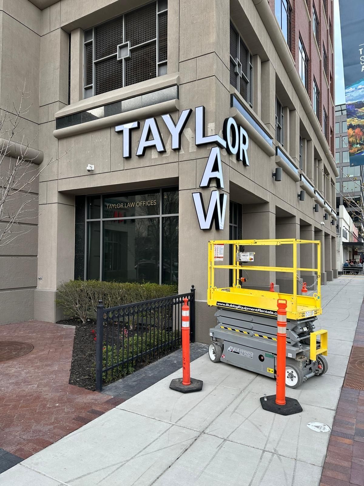 Taylor Law office exterior with a scissor lift on the sidewalk.