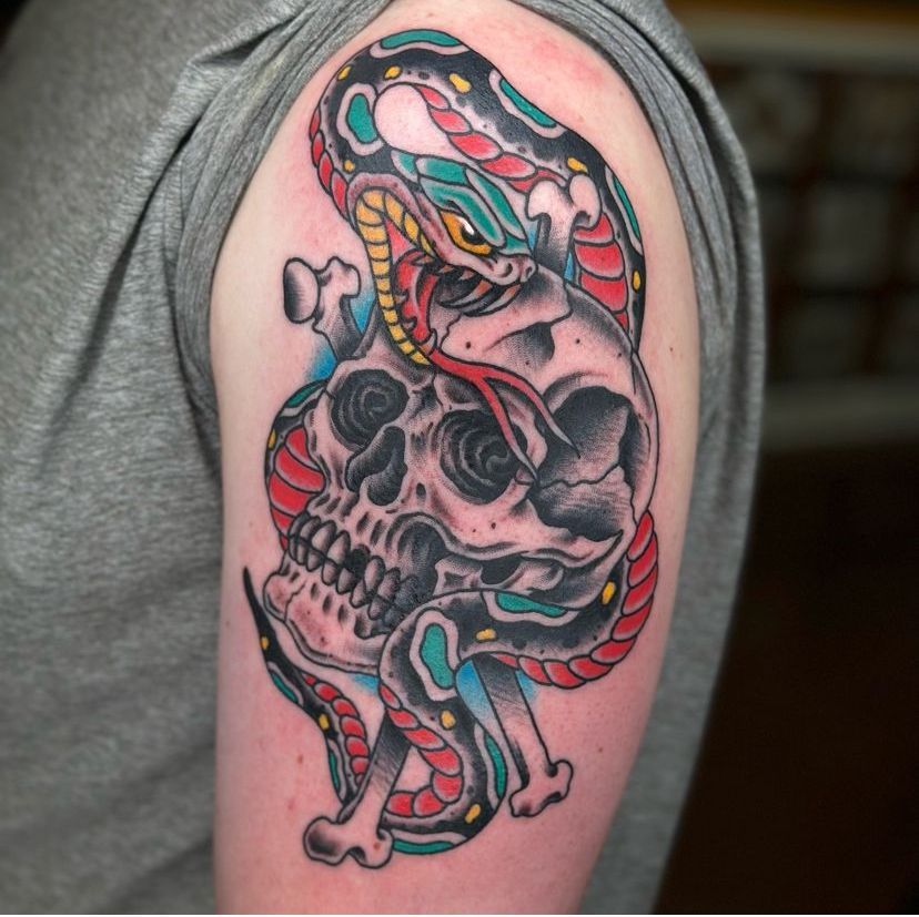 a tattoo of a snake and a skull on a man's arm
