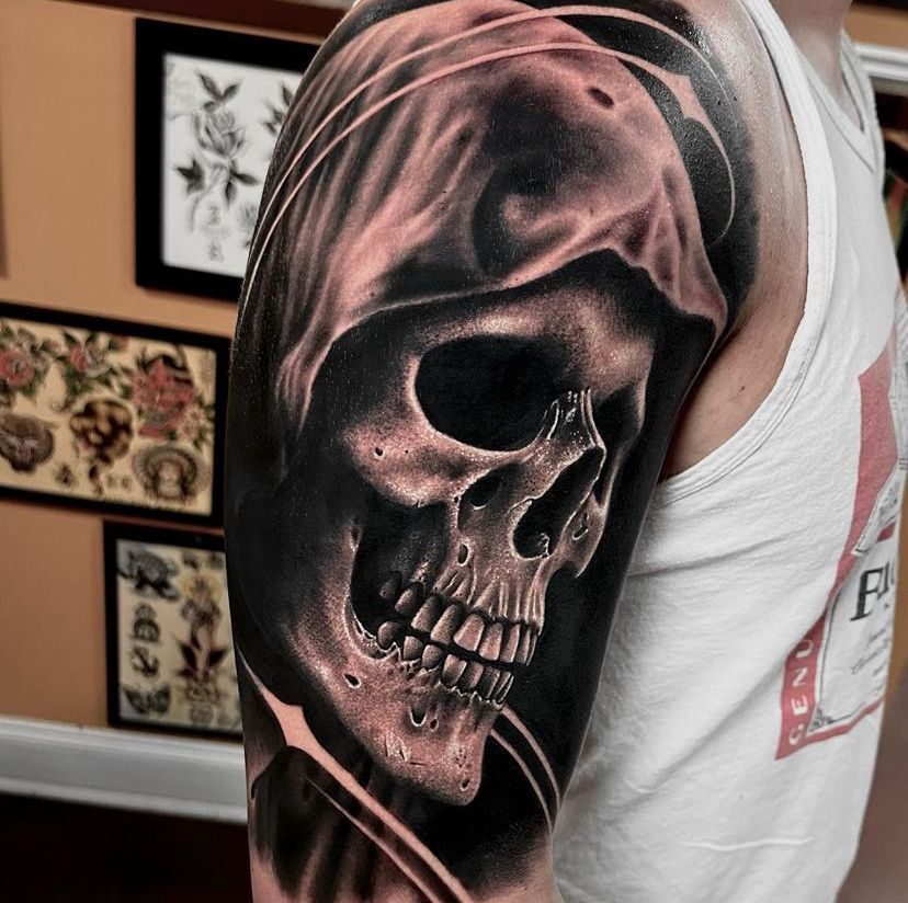 a man has a tattoo of a skull on his arm