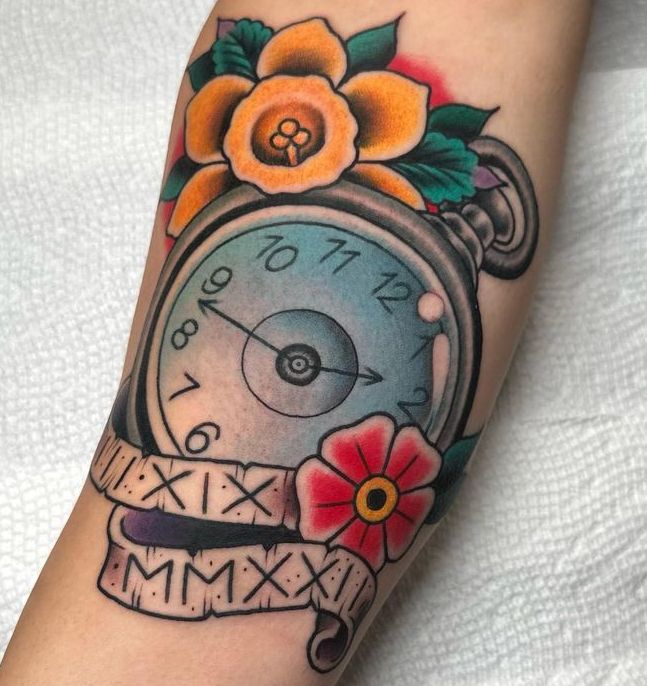 a tattoo of a pocket watch with roman numerals and flowers