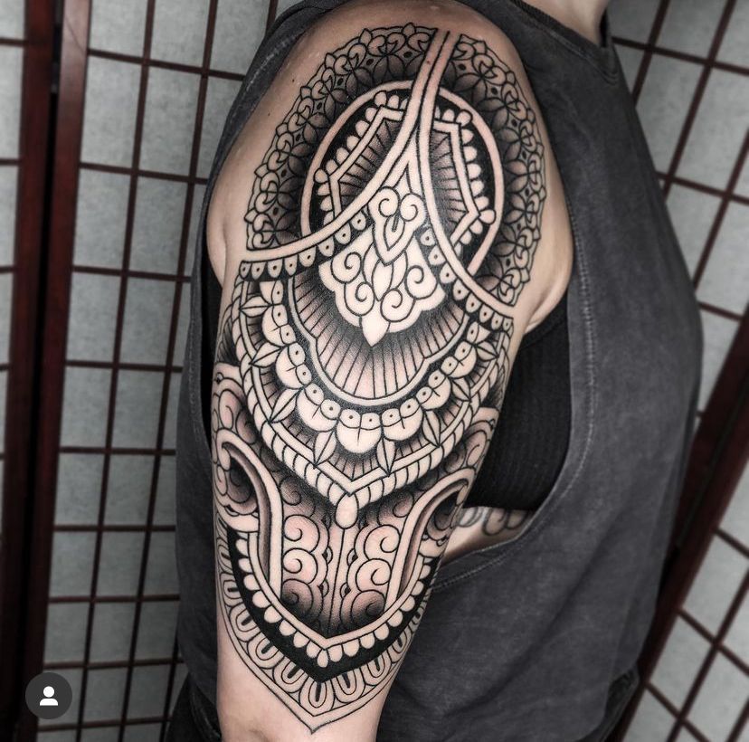 a man has a tattoo on his arm and shoulder