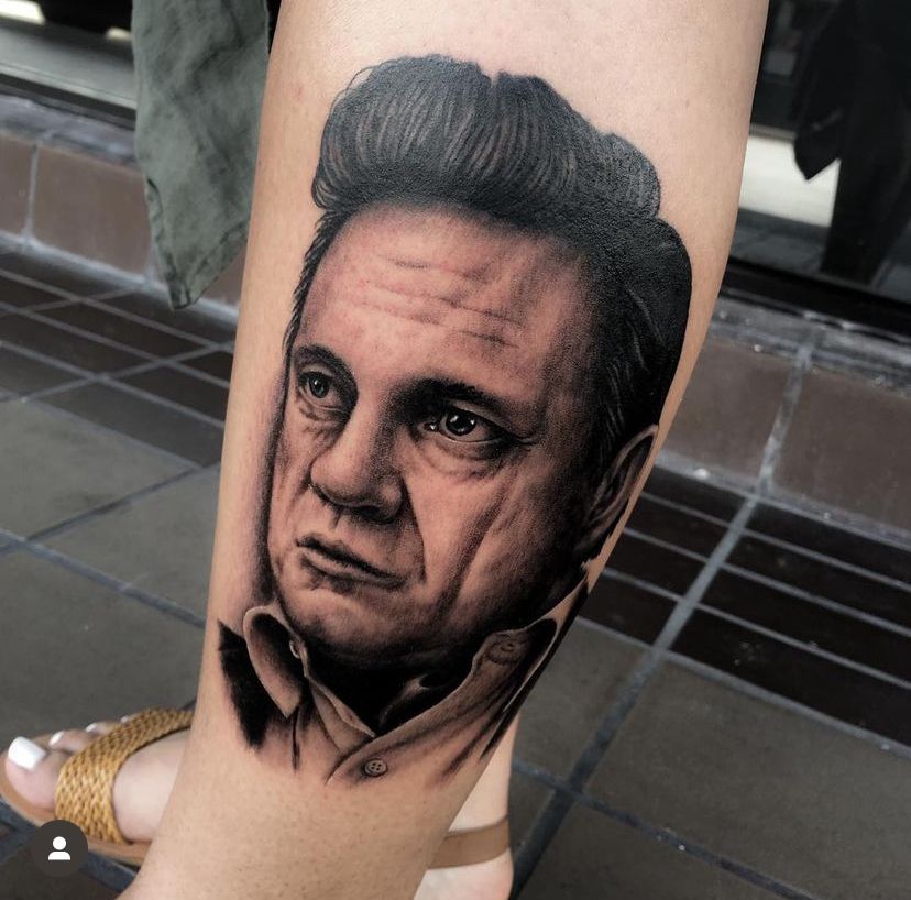a woman has a tattoo of Johnny Cash on her leg