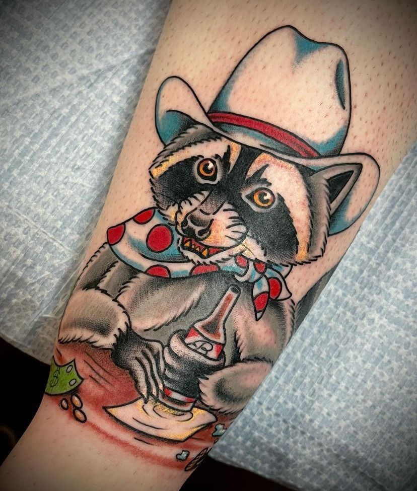 a tattoo of a raccoon wearing a cowboy hat and scarf