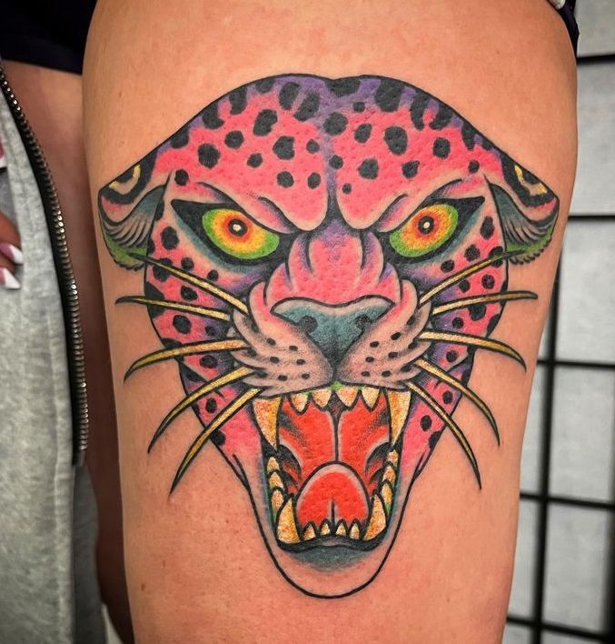 a woman has a tattoo of a pink leopard on her leg