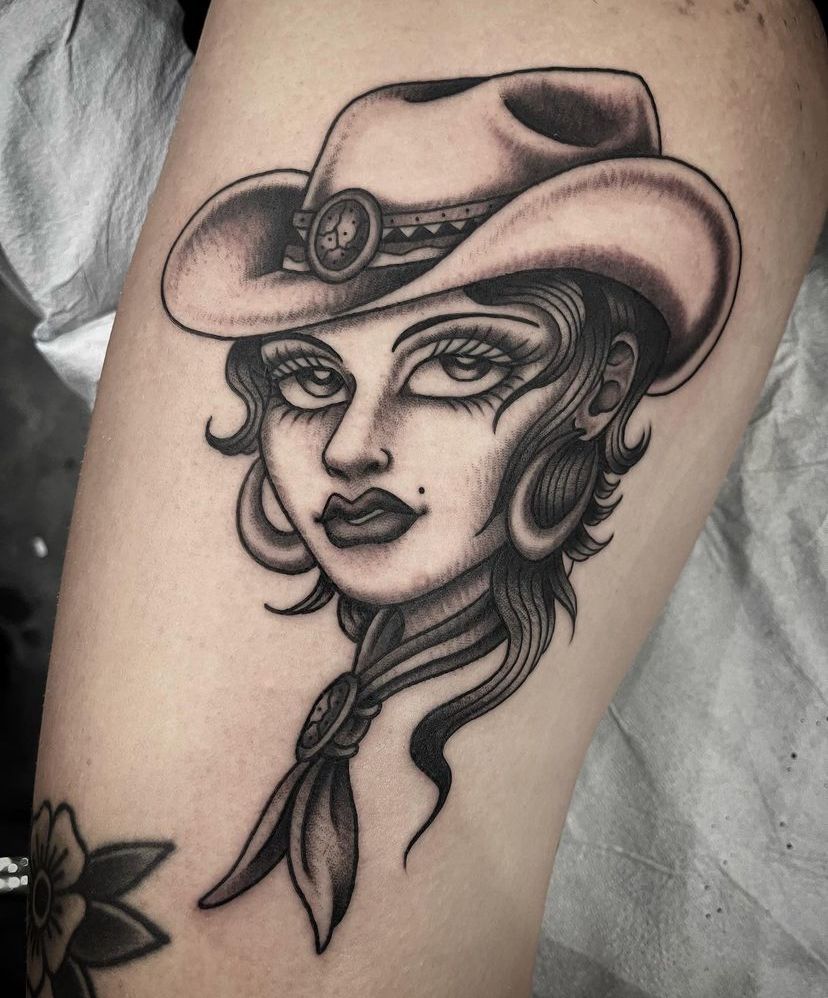 a black and white tattoo of a woman wearing a cowboy hat