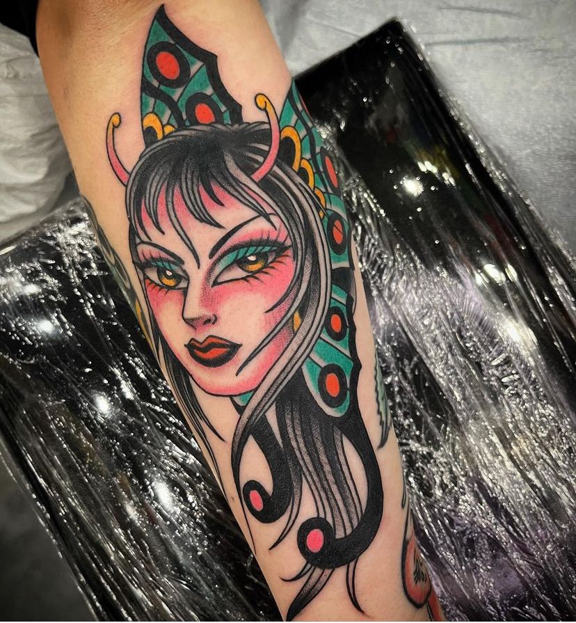 a tattoo of a woman with horns on her head