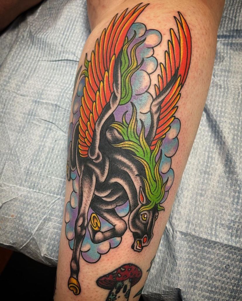 a person has a tattoo of a zebra with wings on their leg