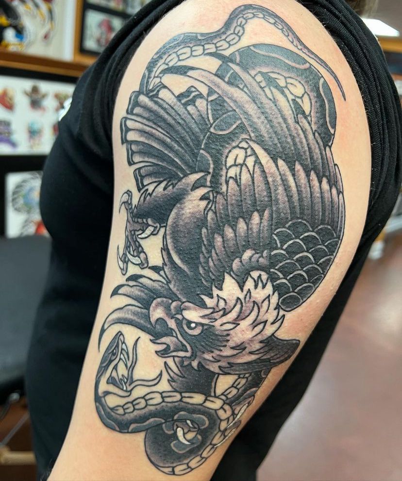 a woman has a tattoo of an eagle and a snake on her arm