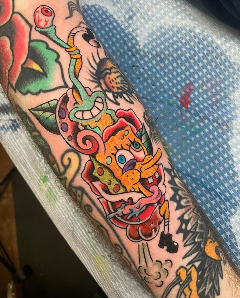 a person has a tattoo of spongebob on their arm