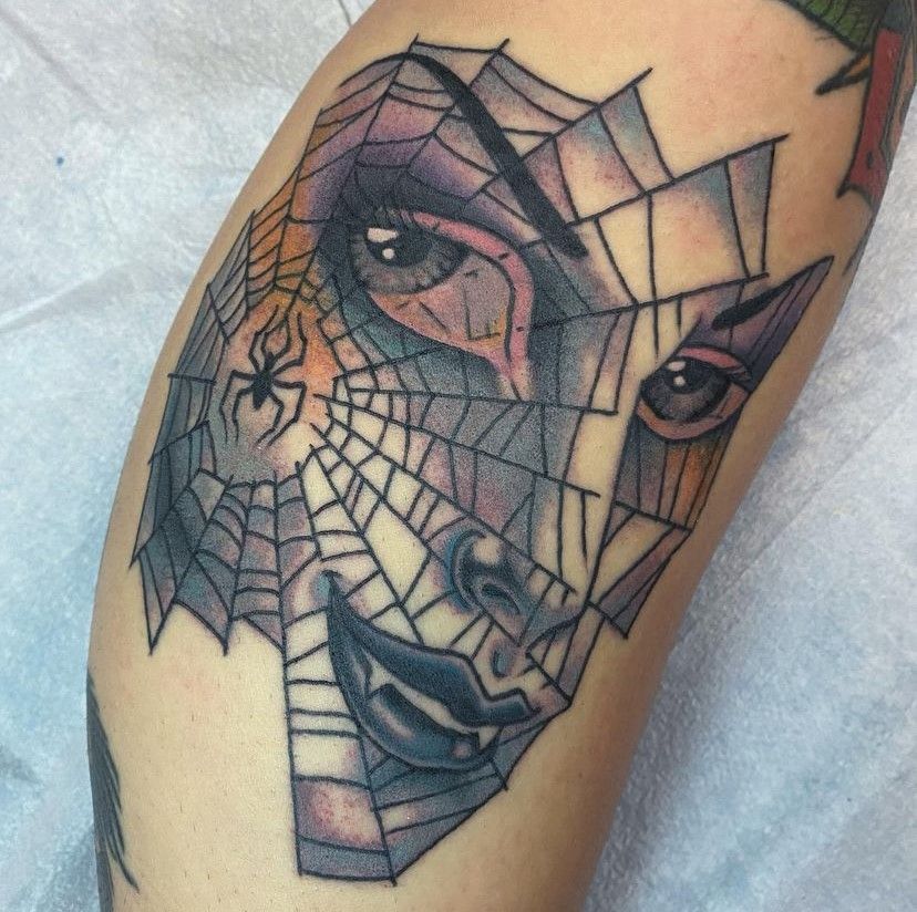 a tattoo of a woman with a spider web around her face