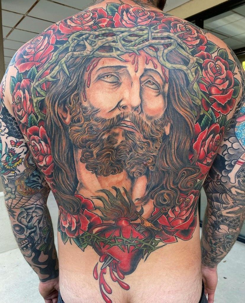 a man has a tattoo of Jesus on his back