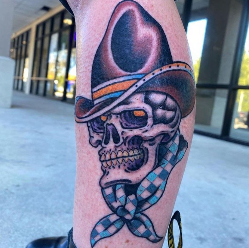 a tattoo of a skull wearing a cowboy hat and scarf