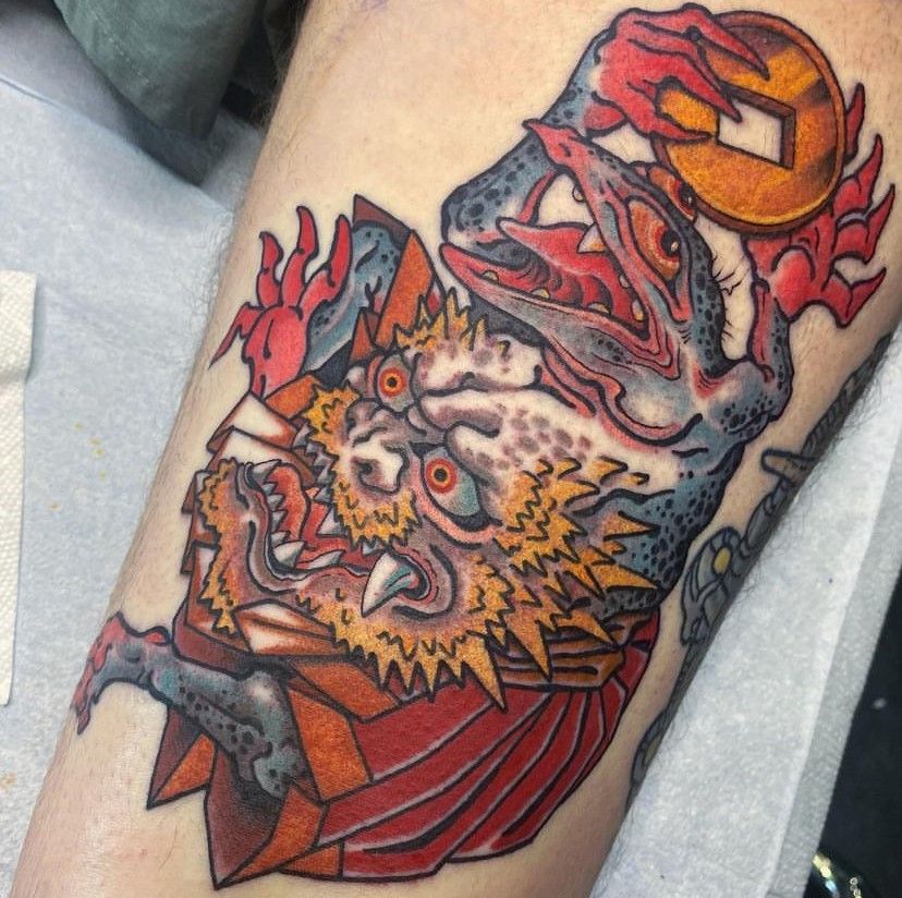 a tattoo of a frog with a crown on its head