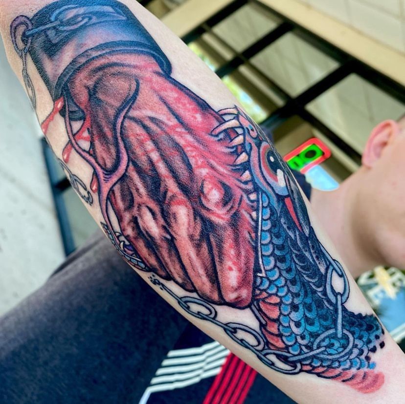 a man has a tattoo of a hand with chains around it