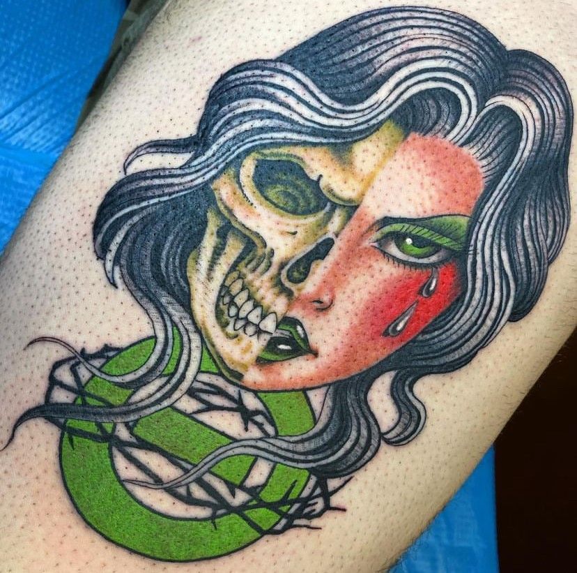 a tattoo of a woman with a skull on her face