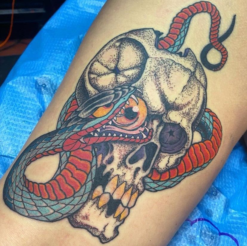 a tattoo of a skull with a snake around it