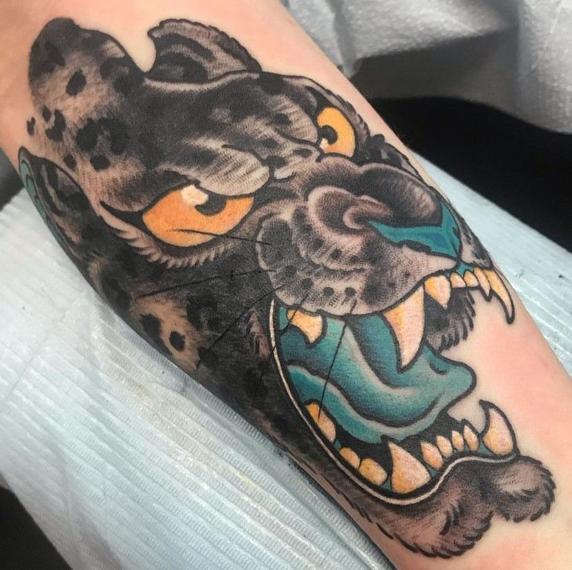 a tattoo of a leopard with its mouth open