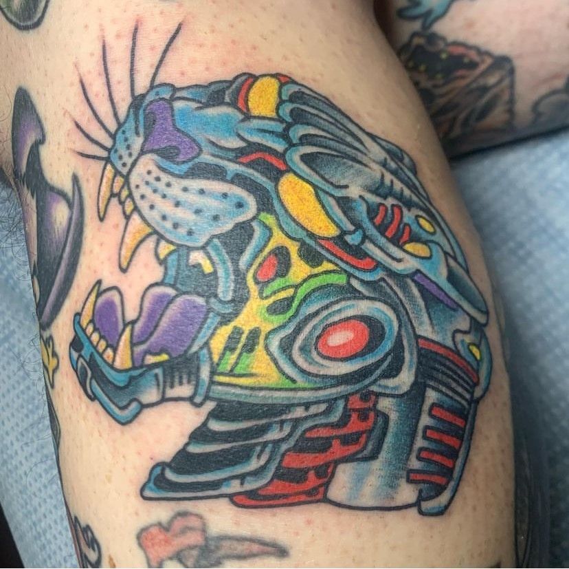 a colorful tattoo of a panther on a person's leg