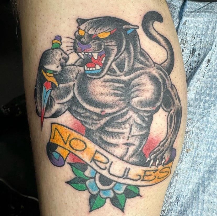 a tattoo of a panther with a banner that says no rules