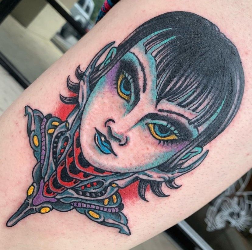 a tattoo of a woman's face on a person's arm