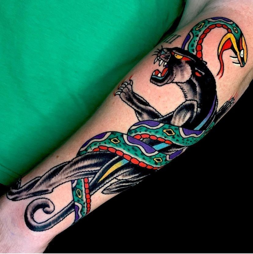 a tattoo of a panther and a snake on a person's arm