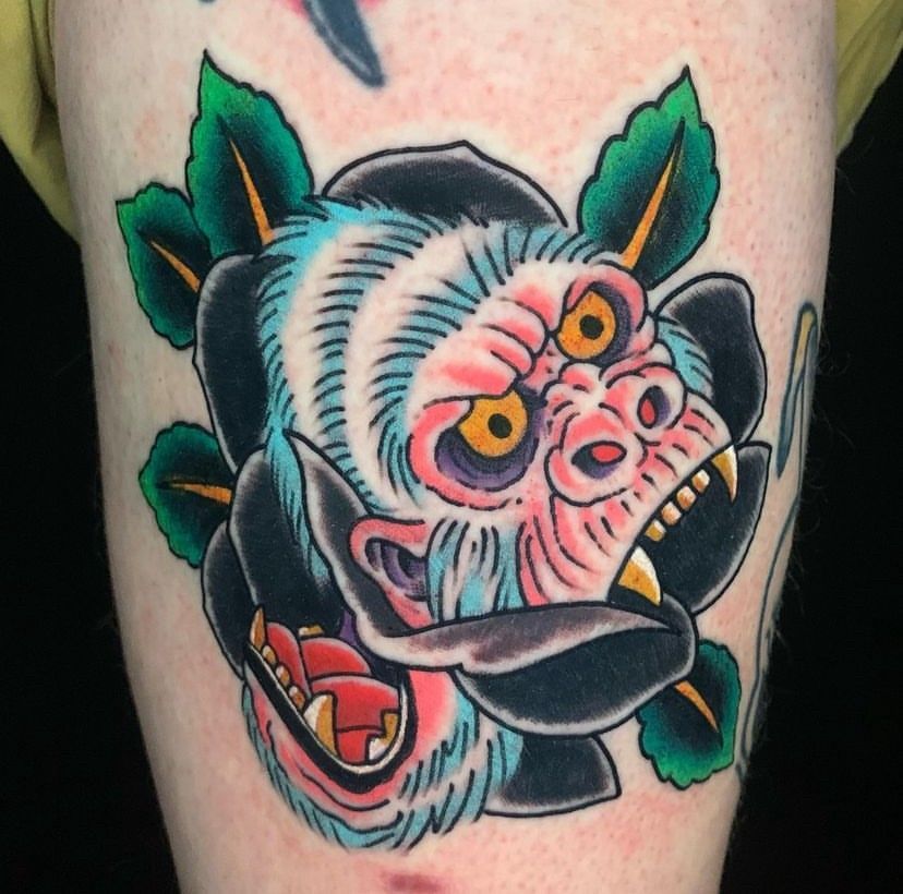 a tattoo of a monkey and a rose on a person's leg